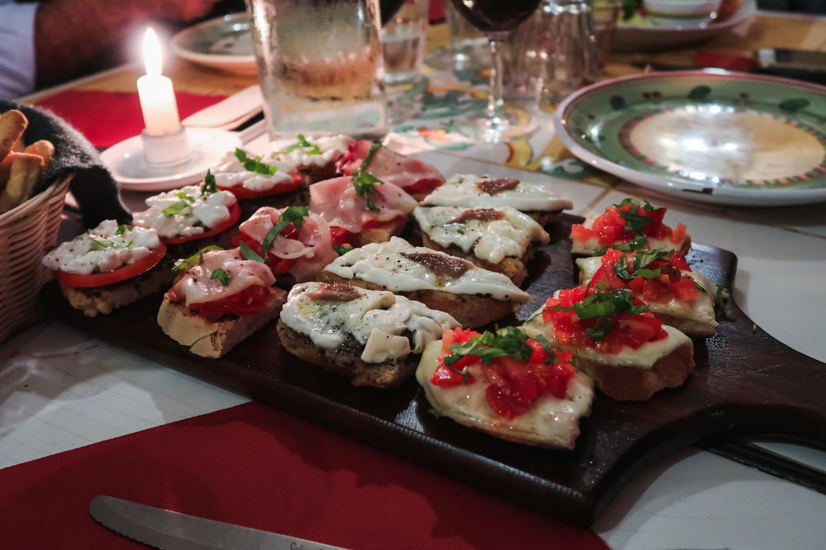 Assorted cicchetti on a wooden counter in a Venice bacaro — small toasts topped with fish, vegetables, and cured meats